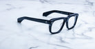 Jacques Marie Mage Yves black rectangular eyeglasses with clear lenses, front view.