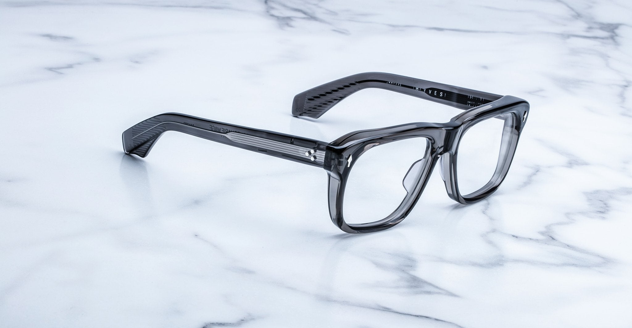 Jacques Marie Mage Yves translucent gray rectangular eyeglasses, top view, displayed on a surface.