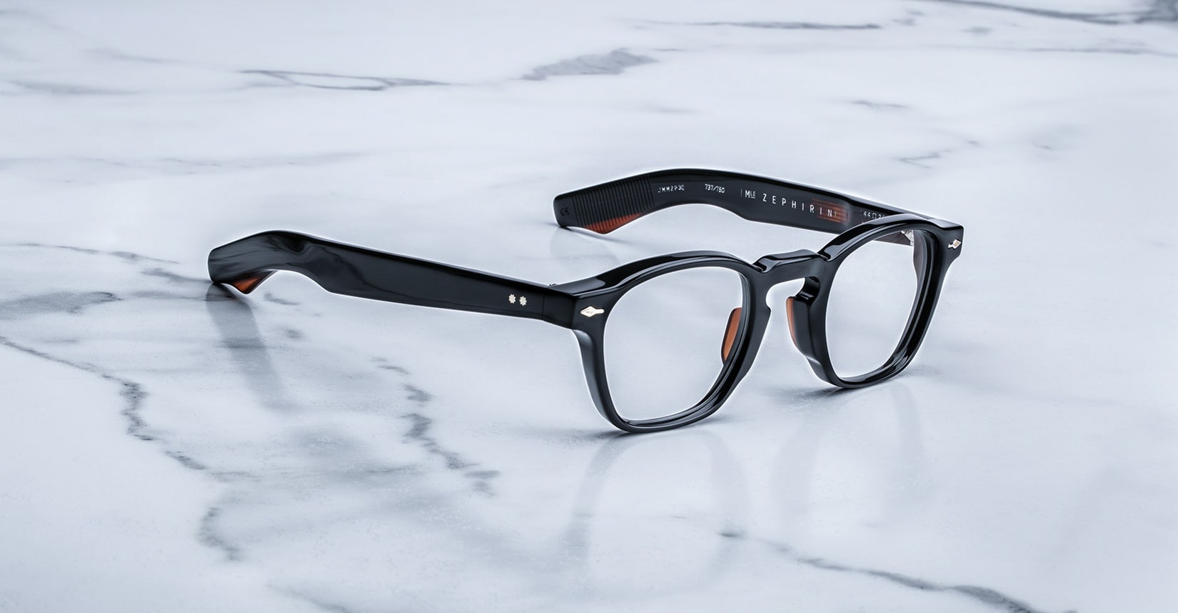 A pair of Jacques Marie Mage Zephirin eyeglasses by Jacques Marie Mage rests elegantly on a white marble surface.