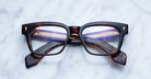 Jacques Marie Mage Molino rectangular tortoiseshell eyeglasses with gold-detailed arms, top-down view.