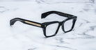 Jacques Marie Mage Molino black rectangular eyeglasses with gold temple accents, front view.
