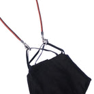 A black face mask with ear loops is attached to the Stretch Cord Necklace Chain for Face Masks with silver clasps, displayed on a white background.