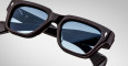 Close-up of Jacques Marie Mage Fellini eyeglasses with dark frames and light blue tinted lenses, highlighting the detailed frame and arms against a plain, light background.