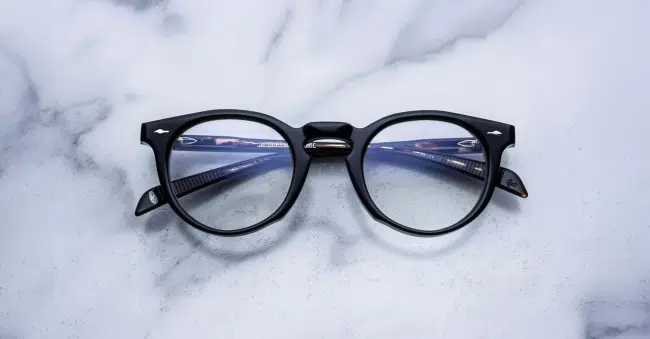 Front view of Jacques Marie Mage Percier optical frame in Noir 5 black acetate with clear lenses, sitting on a marbled background
