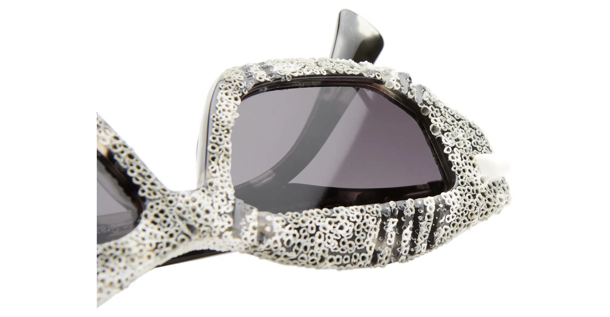 Kuboraum-Q6-HG-WC-White-Coral-KRS0Q6HG00WC252Y-Detail3-Dan-Deutsch Close-up of Kuboraum Q6 sunglasses featuring thick, textured frames in white and gray with a coral-like design and dark tinted lenses—showcasing an organic, distinctive look.