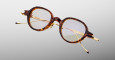 The Jacques Marie Mage Clark eyeglasses feature round tortoiseshell acetate frames and gold metal temples, displayed on a light gray background.