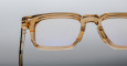 Close-up of the upper half of Jacques Marie Mage Moscova transparent brown rectangular eyeglasses set against a neutral gradient background.