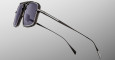The Jacques Marie Mage Earl sunglasses feature rectangular dark lenses, a thick silver and black frame, and slim black metal arms, displayed against a plain gradient background.