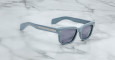 The Jacques Marie Mage Molino 55: light blue square sunglasses with dark lenses and thick frames are displayed on a white marble surface.