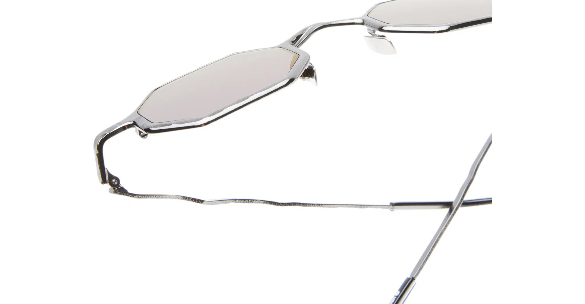 Kuboraum-Z19-GMG-Gun-Metal-KRSZ19GMG00000GF-Detail2-Dan-Deutsch Close-up of Kuboraum Z19 sunglasses featuring metal frames, angular geometric shapes, and light-tinted lenses. The jagged texture of the arms is highlighted against a white background.