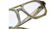 Close-up of transparent olive-green Kuboraum K33 eyeglass frames with clear lenses, highlighting frame details, lens markings, and product info on the inner temple.
