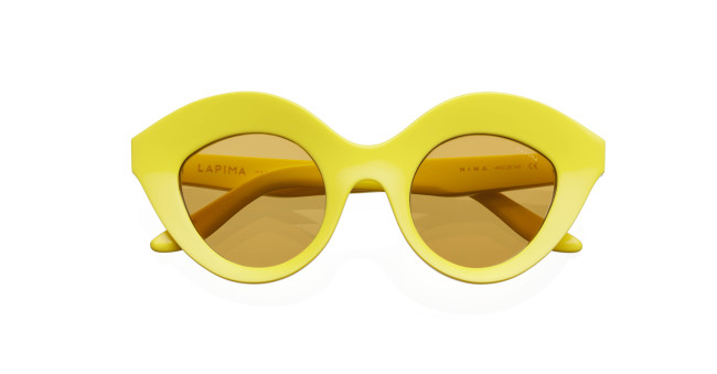 The Lapima Nina sunglasses feature thick, glossy round yellow frames with brown-tinted lenses and the Lapima brand name on the left inner arm.