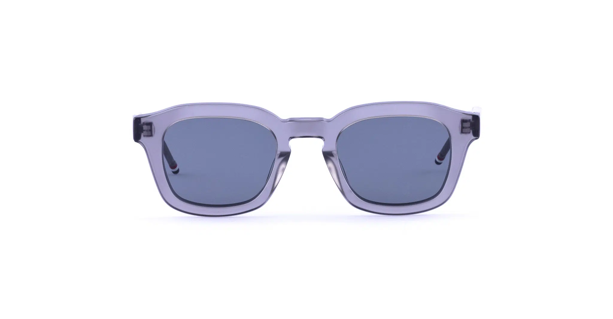 Rectangular Thom Browne 412 Sunglasses with transparent gray frames and dark tinted lenses, shown from the front against a white background.