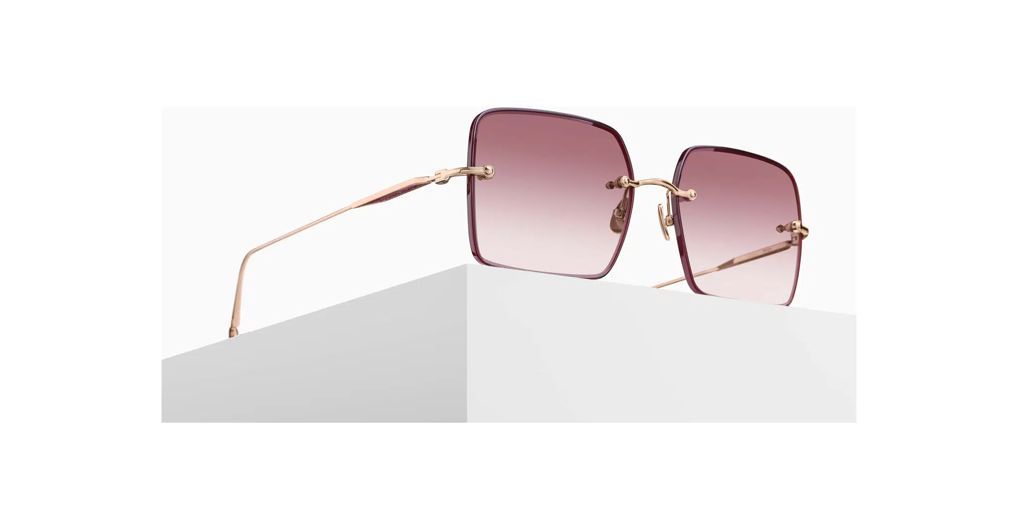 3/4 view of the Matsuda M5005 sunglass in rose gold with rose gradient lenses on a pedestal