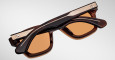 The Jacques Marie Mage Sonata sunglasses, featuring brown square frames and gold metal accents, are shown upside down with temples and top of the frames visible against a plain light background.