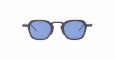 A pair of Thom Browne sunglasses with thick, black geometric frames and blue-tinted square lenses.
