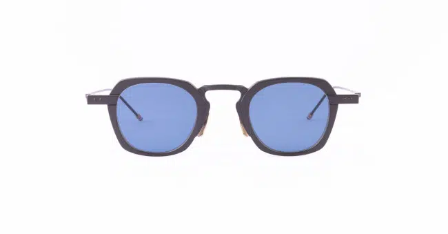 A pair of Thom Browne sunglasses with thick, black geometric frames and blue-tinted square lenses.