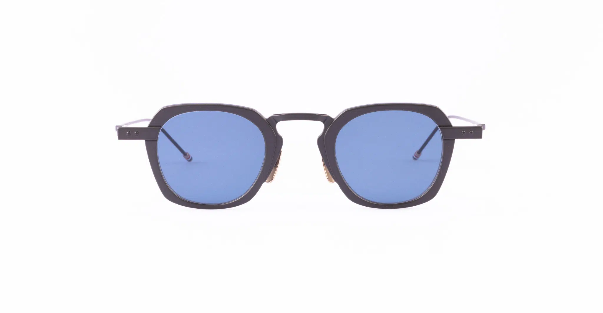 A pair of Thom Browne sunglasses with thick, black geometric frames and blue-tinted square lenses.