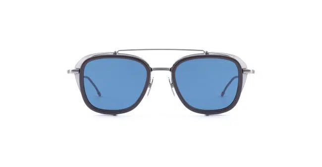 A pair of Thom Browne sunglasses with a black frame, blue-tinted lenses, and a thin metal double bridge, shown facing forward on a white background.
