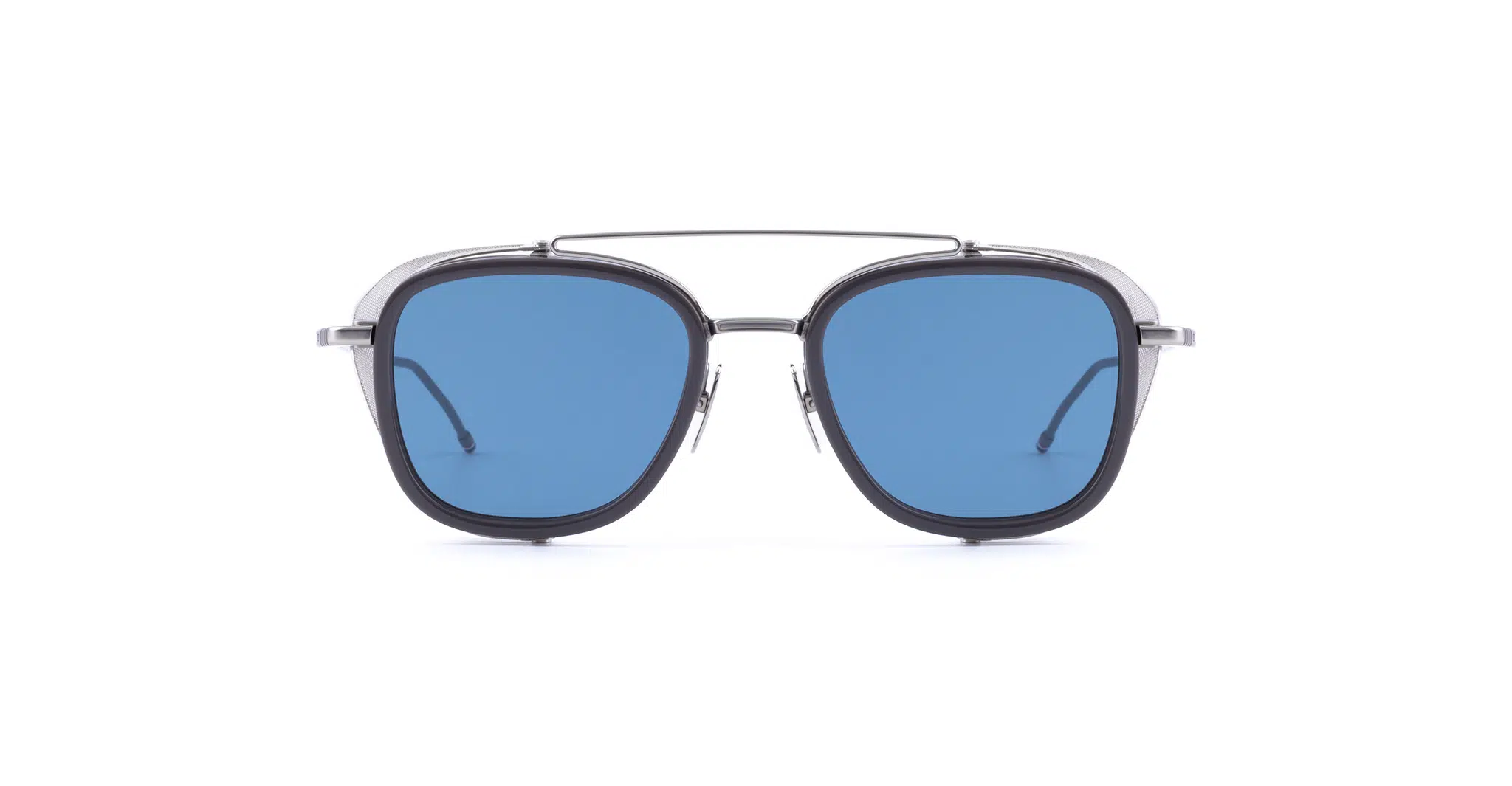 A pair of Thom Browne sunglasses with a black frame, blue-tinted lenses, and a thin metal double bridge, shown facing forward on a white background.