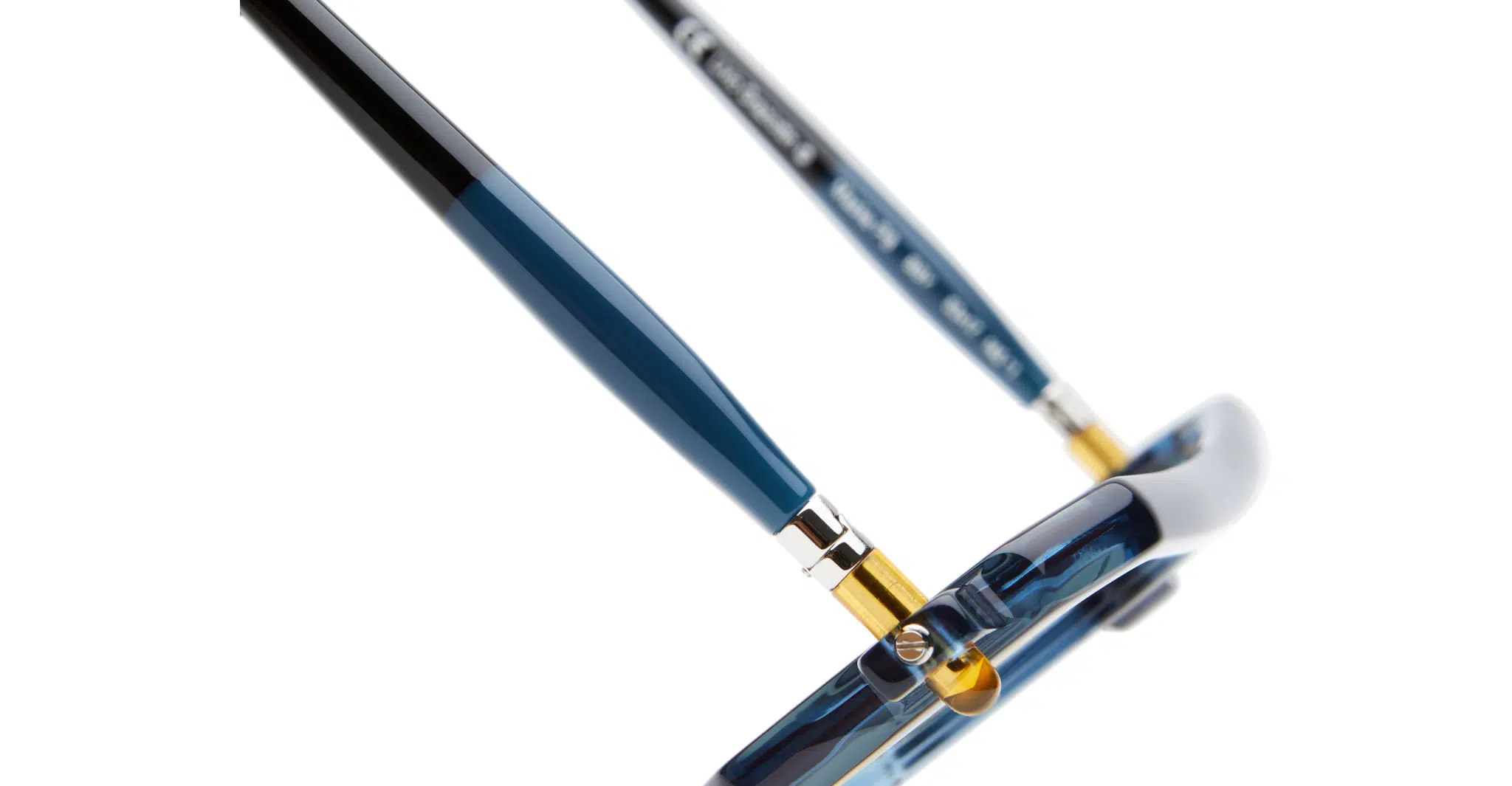 Kuboraum-P8-BBY-Biscay-Blue-KRS0P8BBY000002R-Detail2-Dan-Deutsch Close-up of the side arms and hinges of Kuboraum P8 blue and black eyeglasses with gold accents, showing part of the frame and temple tips against a white background.