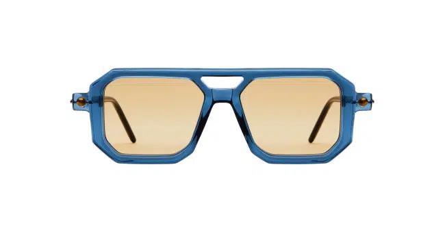 The Kuboraum P8 sunglasses feature thick blue geometric frames and light brown lenses, shown from the front against a white background.