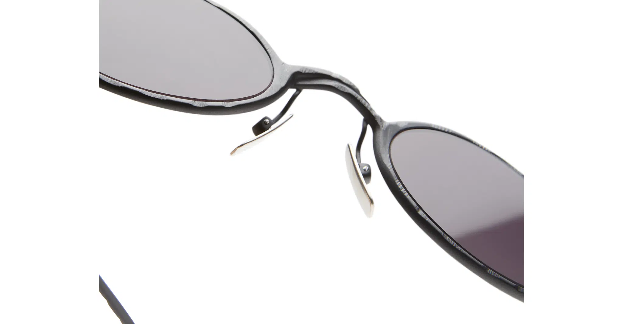 Close-up view of Kuboraum Z24 black round sunglasses with dark lenses, highlighting the nose pads and part of the frame against a white background.