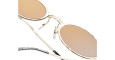 Close-up of Kuboraum Z24 gold-framed sunglasses featuring round mirrored lenses and clear adjustable nose pads, photographed against a white backdrop.