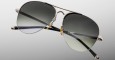 The Jacques Marie Mage Amelia sunglasses feature aviator-style silver metal frames, dark gradient lenses, and black temples, displayed against a light gray background.