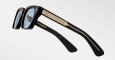 Jacques Marie Mage Quentin sunglasses in black with light blue lenses, gold detailing, and engraved temple patterns, shown on a plain white background.