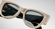 A close up view of a pair of Jacques Marie Mage Chelsea beige, thick-framed sunglasses with dark lenses