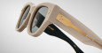 A close up profile view of a pair of Jacques Marie Mage Chelsea beige, thick-framed sunglasses with dark lenses