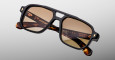 Jacques Marie Mage Evans sunglasses in black and tortoiseshell with brown-tinted lenses, geometric frames, and gold detailing, showcased on a light gray background.