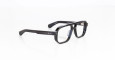 A pair of Jacques Marie Mage Evans black rectangular eyeglasses with thick frames and clear lenses rests on a white surface.