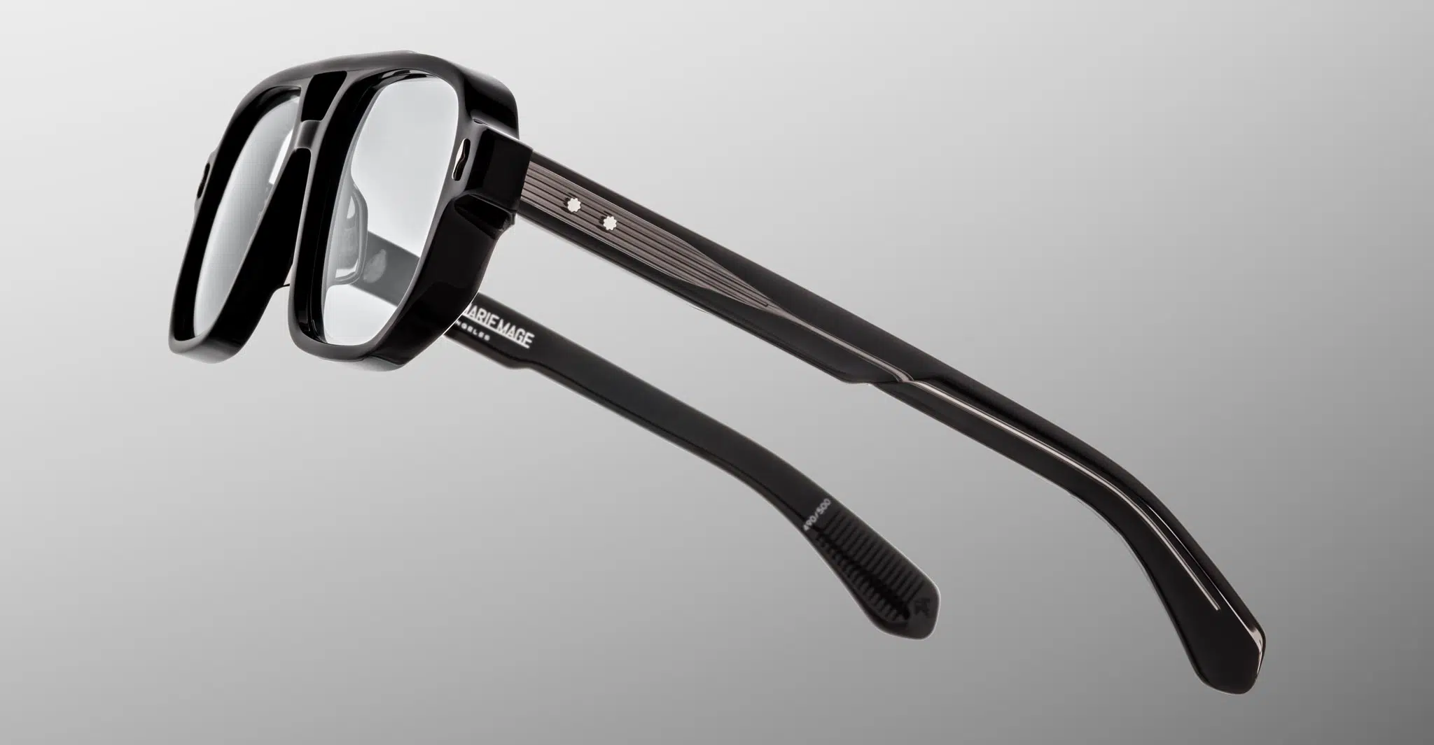 A pair of Jacques Marie Mage Evans eyeglasses with black rectangular frames and thick arms, displayed at an angle on a plain light gray background.