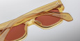 Close-up of Jacques Marie Mage Fellini sunglasses: translucent yellow frames with brown lenses, subtle geometric pattern on the arms, and a white logo by the hinge, shown against a plain light background.