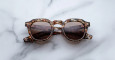 Jacques Marie Mage Firehole River: round tortoiseshell sunglasses with dark lenses, shown on a white marble surface.