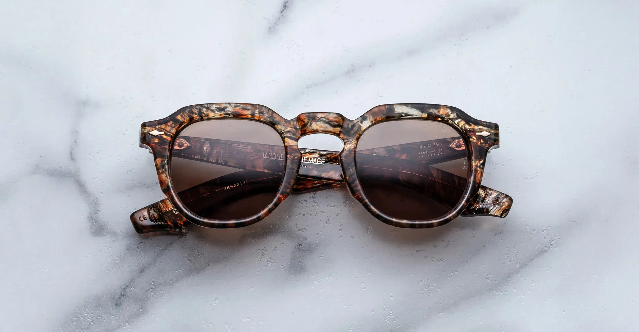 Jacques Marie Mage Firehole River: round tortoiseshell sunglasses with dark lenses, shown on a white marble surface.