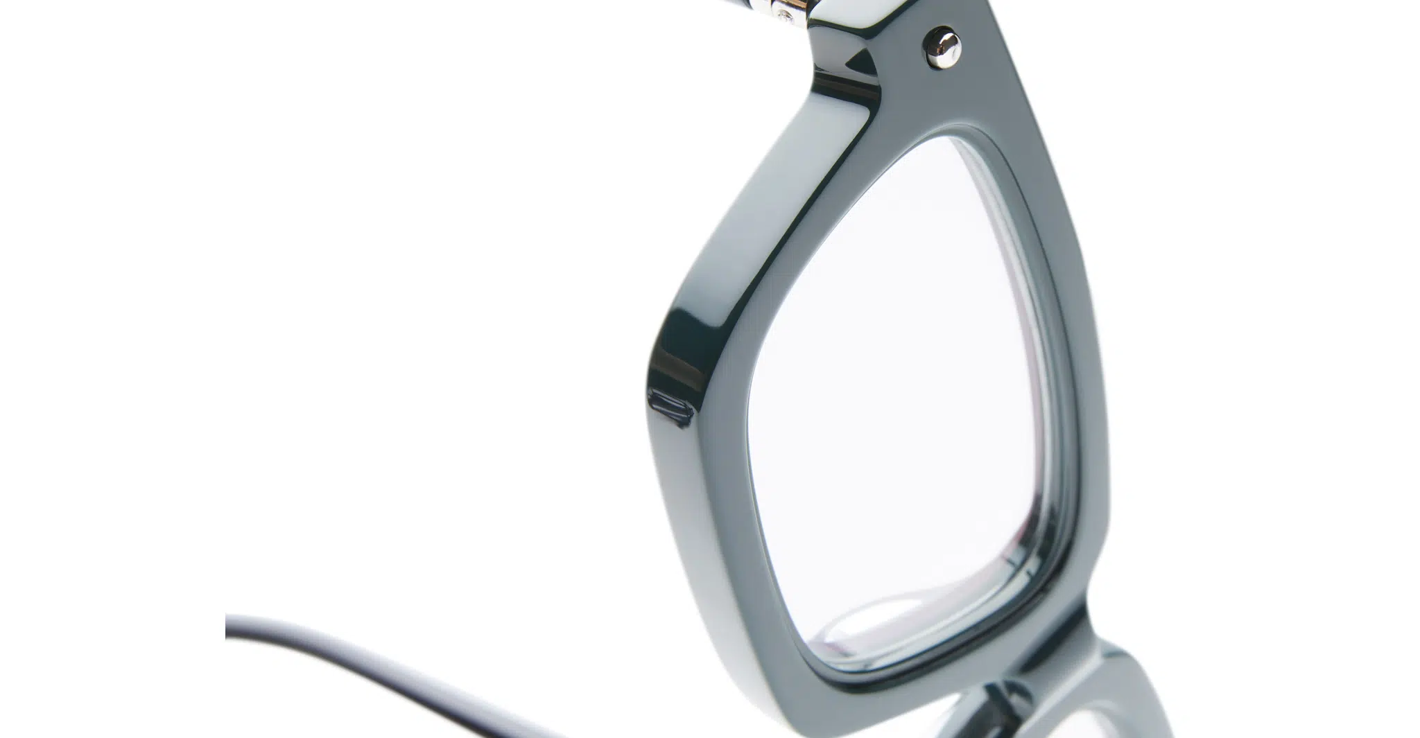 Close-up of the side and lens of the Kuboraum P25 eyeglasses, featuring thick, glossy dark green frames. Set against a white background, only part of the frame and lens is visible.