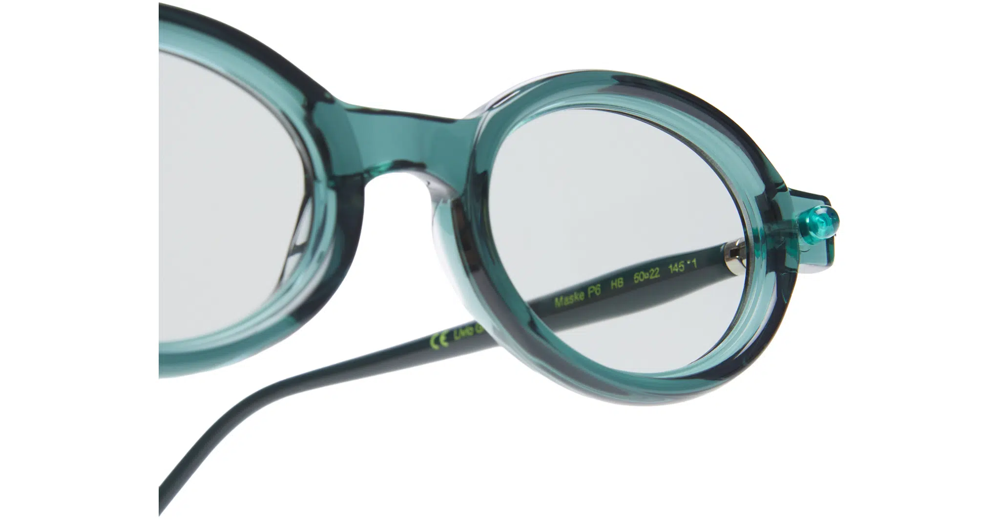 Close-up of a pair of round, teal-colored eyeglasses with transparent lenses and black temples, set against a white background.
