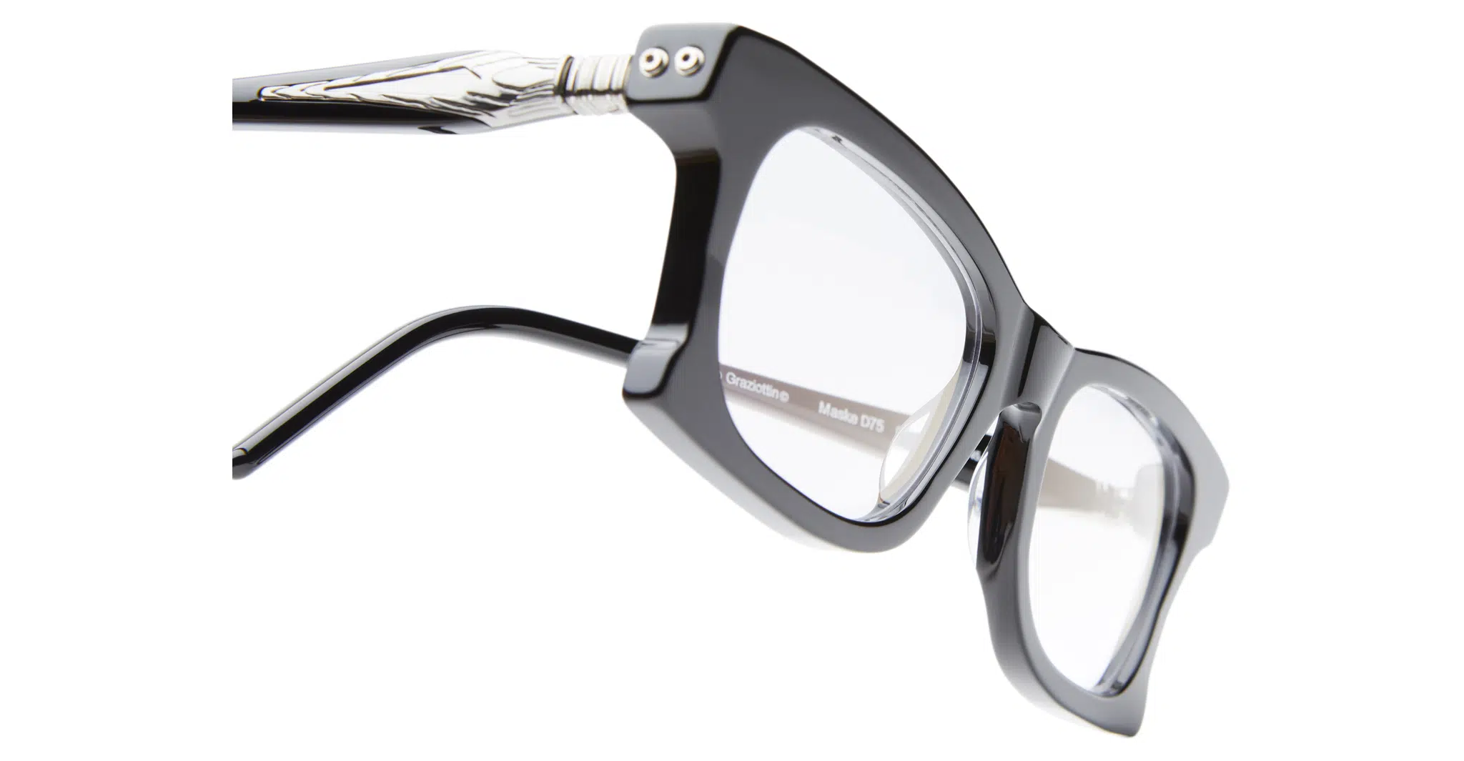 Close-up of Kuboraum D75 black square eyeglasses with clear lenses, silver metal hinge, and decorative temple detail, shown at an angle on a white background.