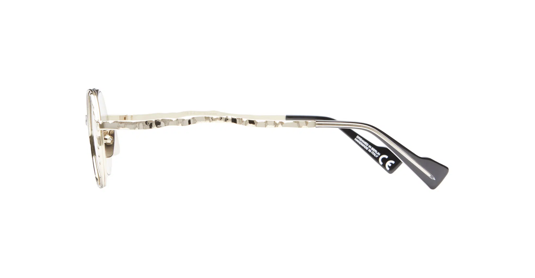 Kuboraum-H11-GMG-Gun-Metal-KRSH11GMG000002F-Side-Dan-Deutsch Side view of Kuboraum H11 gold metal eyeglass frames featuring hammered arm texture and black plastic temple tips, set against a white background.