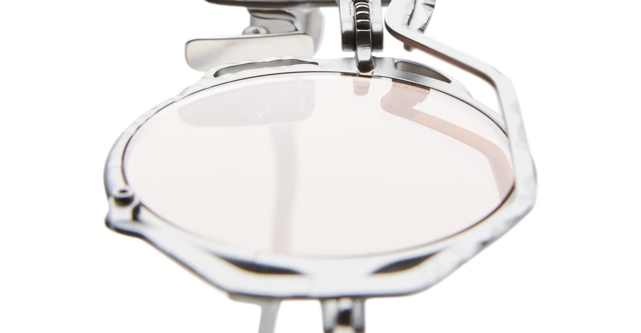 Kuboraum-Z50 RB_MATT DARK GUN METAL 11-Dan-Deutsch Close-up view of a single round Kuboraum Z50 lens held in a metallic optical device, likely a lens testing or fitting tool, against a white background.