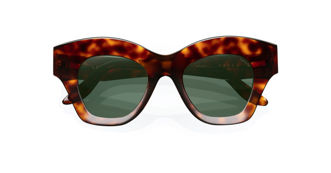Lapima Tessa sunglasses feature thick, oversized tortoiseshell frames and dark green lenses, shown against a white background.