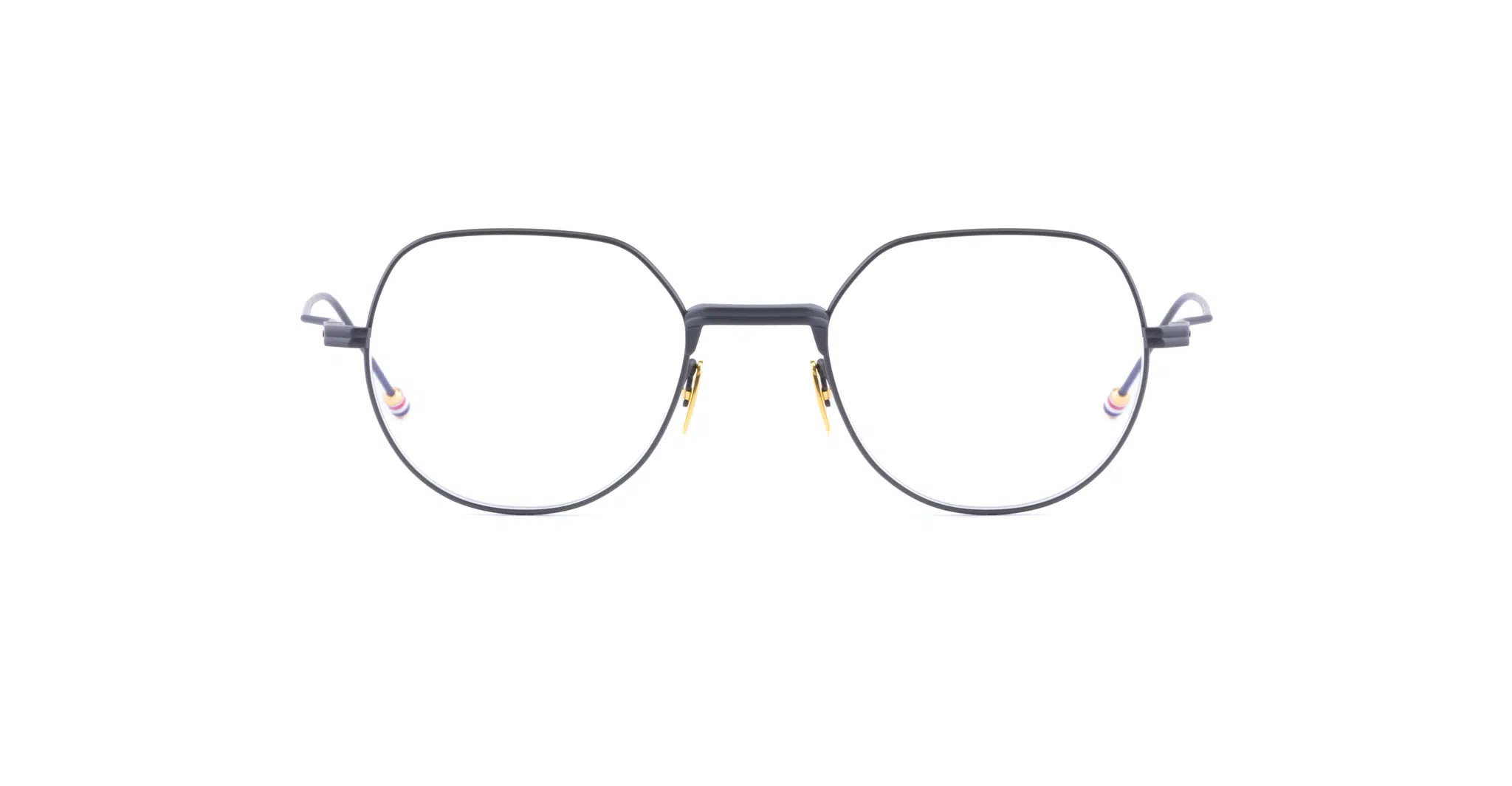 Thom Browne 935: Black round eyeglasses with a thin metal frame, gold accents on the nose bridge and hinges, and clear lenses, displayed against a white background.
